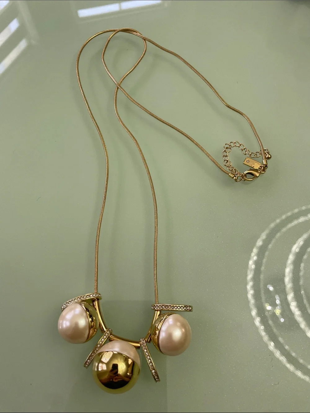 Kate Spade New York Pendant in gold with pearls long chain.